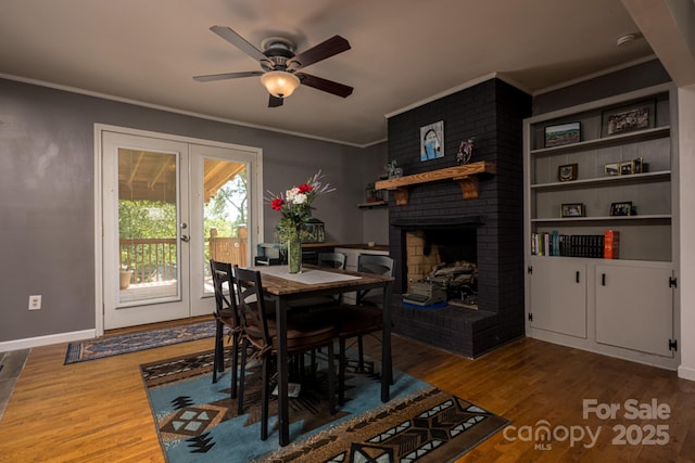 69 Katydid Dr, Marion, NC 28752 - dining room featuring wood finished floors, crown molding, a brick fireplace, a ceiling fan, and french doors