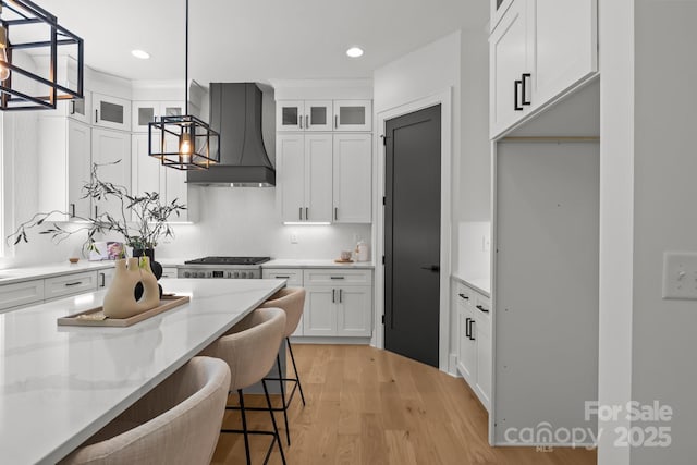 3937 Plainview Rd, Charlotte, NC 28208 - kitchen with wall chimney range hood, white cabinets, glass insert cabinets, and recessed lighting