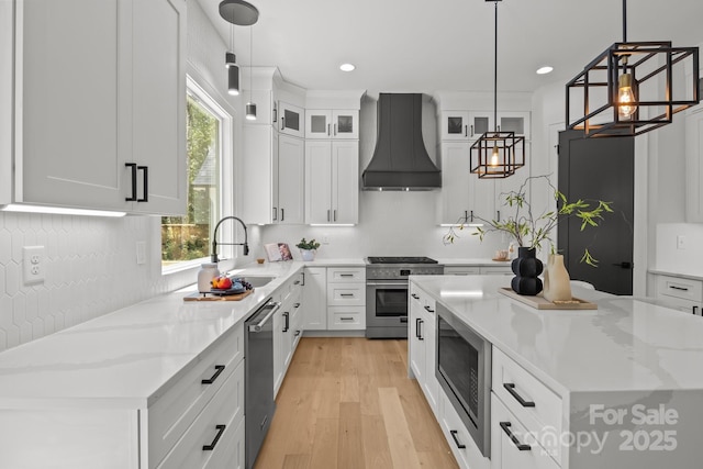 3937 Plainview Rd, Charlotte, NC 28208 - kitchen with custom range hood, stainless steel appliances, white cabinetry, light wood-style floors, and a kitchen island