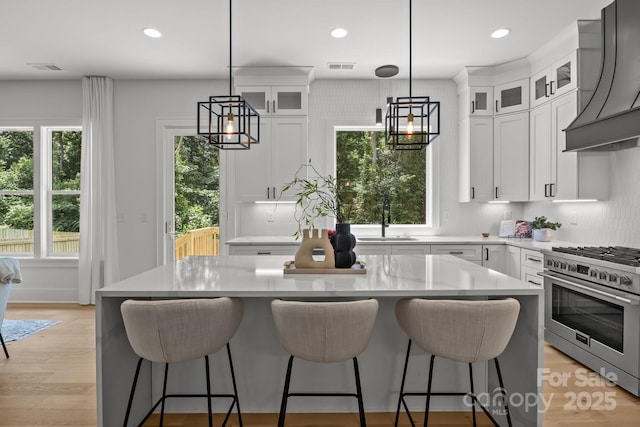 3937 Plainview Rd, Charlotte, NC 28208 - kitchen featuring high end range, premium range hood, light countertops, a kitchen island, and recessed lighting