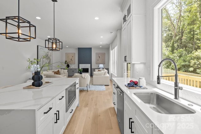 3937 Plainview Rd, Charlotte, NC 28208 - kitchen with white cabinetry, appliances with stainless steel finishes, recessed lighting, decorative light fixtures, and light wood-type flooring
