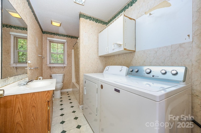 38367 Loblolly Ln, New London, NC 28127 - laundry area with washing machine and dryer, a textured ceiling, wallpapered walls, and light tile patterned floors