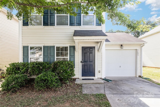 7643 Monarch Birch Ln, Charlotte, NC 28215 - view of exterior entry featuring concrete driveway, roof with shingles, and an attached garage