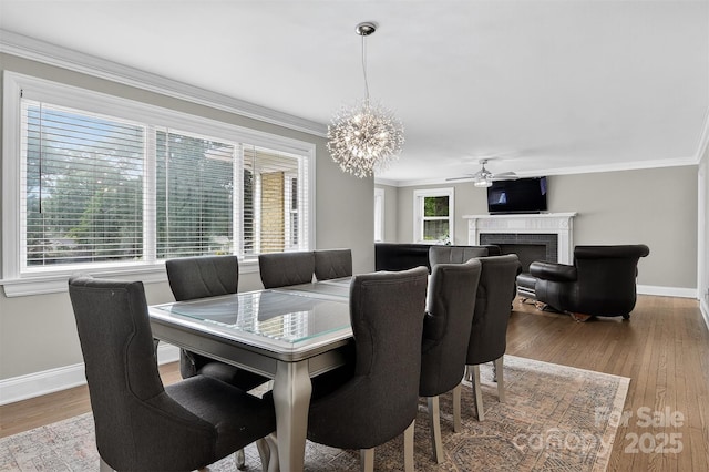 3127 N Center St, Hickory, NC 28601 - dining area featuring a chandelier, wood finished floors, a brick fireplace, ornamental molding, and a ceiling fan