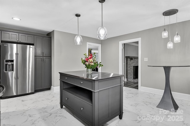 3127 N Center St, Hickory, NC 28601 - kitchen featuring high end fridge, light marble finish flooring, dark countertops, a stone fireplace, and a center island