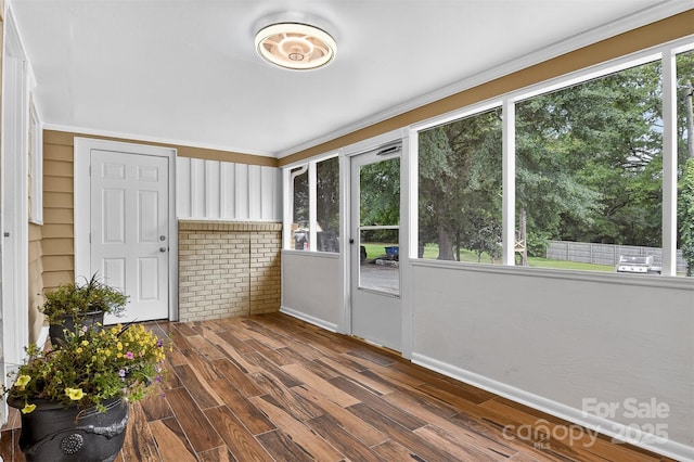 3127 N Center St, Hickory, NC 28601 - unfurnished sunroom featuring plenty of natural light, crown molding, brick wall, and wood finished floors