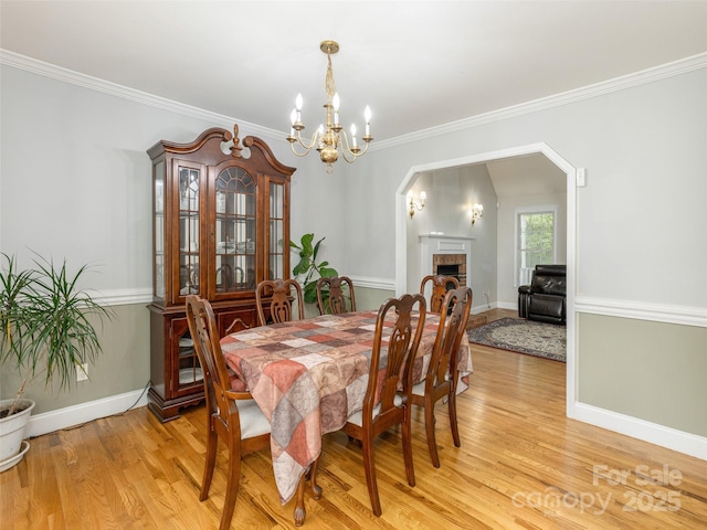 30 Collenwood Rd, Arden, NC 28704 - dining area with a chandelier, light wood-style flooring, a brick fireplace, and ornamental molding