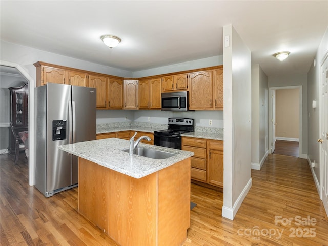 30 Collenwood Rd, Arden, NC 28704 - kitchen with appliances with stainless steel finishes, light wood-type flooring, an island with sink, and light stone counters