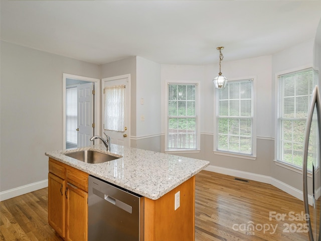30 Collenwood Rd, Arden, NC 28704 - kitchen featuring stainless steel dishwasher, light wood-style flooring, decorative light fixtures, light stone countertops, and an island with sink