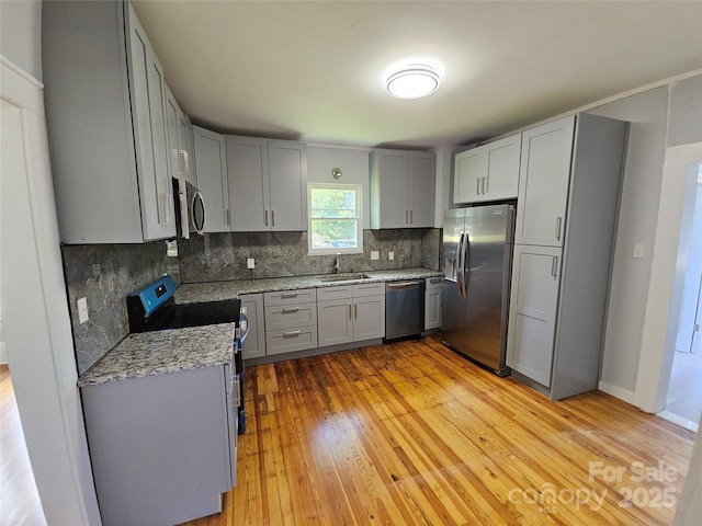 1704 16th St NE, Hickory, NC 28601 - kitchen with stainless steel appliances, gray cabinetry, tasteful backsplash, light wood-style flooring, and light stone counters