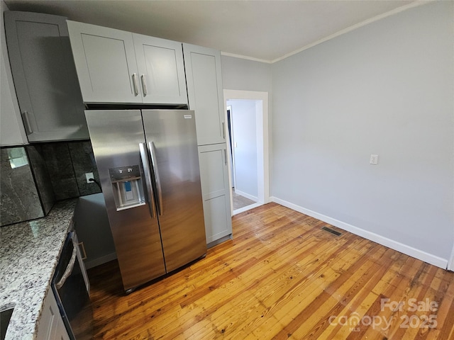 1704 16th St NE, Hickory, NC 28601 - kitchen featuring stainless steel fridge with ice dispenser, light wood-style flooring, ornamental molding, light stone countertops, and backsplash