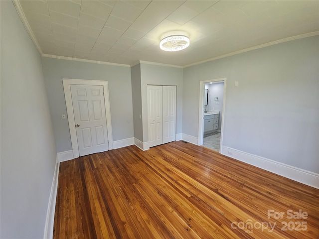 1704 16th St NE, Hickory, NC 28601 - unfurnished bedroom featuring crown molding, hardwood / wood-style flooring, a closet, and ensuite bathroom