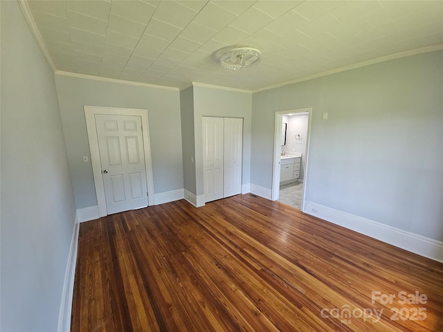 1704 16th St NE, Hickory, NC 28601 - unfurnished bedroom featuring a closet, crown molding, and hardwood / wood-style floors