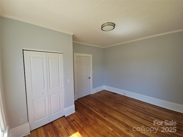 1704 16th St NE, Hickory, NC 28601 - unfurnished bedroom featuring dark wood-style flooring, a closet, and ornamental molding