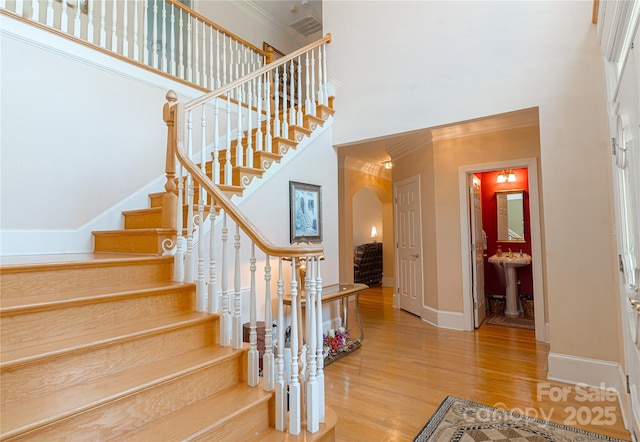 10405 Lady Grace Ln, Charlotte, NC 28270 - stairs with arched walkways, crown molding, a high ceiling, and wood finished floors