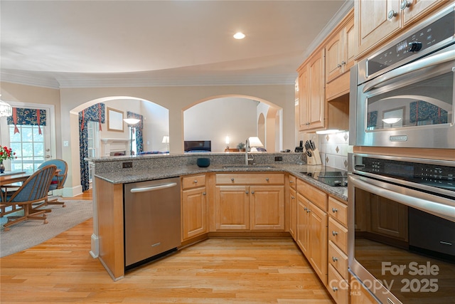 10405 Lady Grace Ln, Charlotte, NC 28270 - kitchen featuring appliances with stainless steel finishes, arched walkways, ornamental molding, light wood-style flooring, and stone countertops