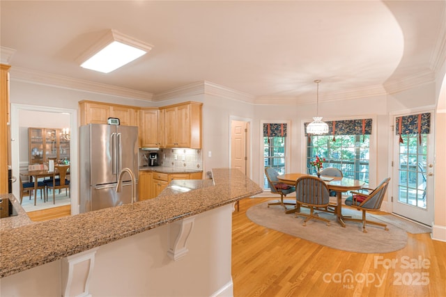 10405 Lady Grace Ln, Charlotte, NC 28270 - kitchen featuring freestanding refrigerator, light brown cabinetry, light stone counters, light wood-type flooring, and ornamental molding