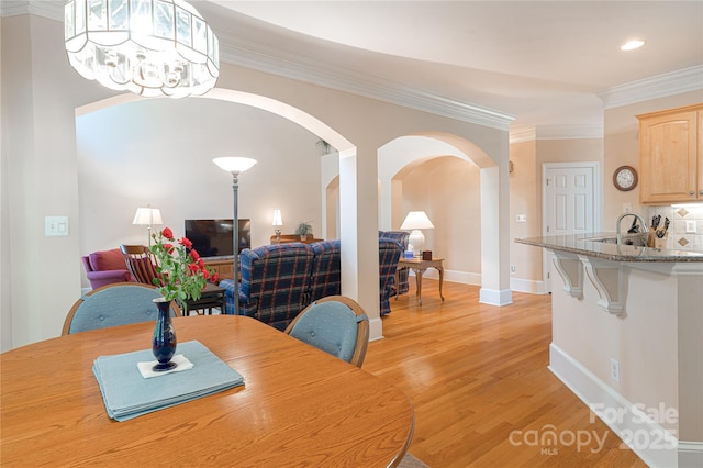 10405 Lady Grace Ln, Charlotte, NC 28270 - dining room with arched walkways, light wood-style floors, ornamental molding, recessed lighting, and a chandelier