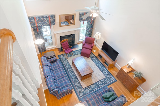 10405 Lady Grace Ln, Charlotte, NC 28270 - living area with a fireplace with flush hearth, wood finished floors, ceiling fan, and a towering ceiling