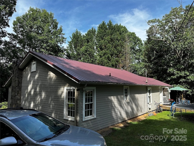 1041 Tomlinson Loop, Connelly Springs, NC 28612 - view of home's exterior featuring a trampoline, a metal roof, and a yard