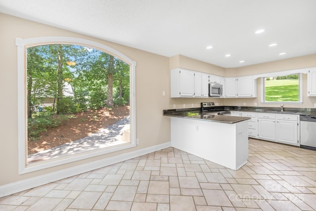 698 Normandy Rd, Mooresville, NC 28117 - kitchen featuring stainless steel appliances, white cabinets, a peninsula, dark countertops, and plenty of natural light