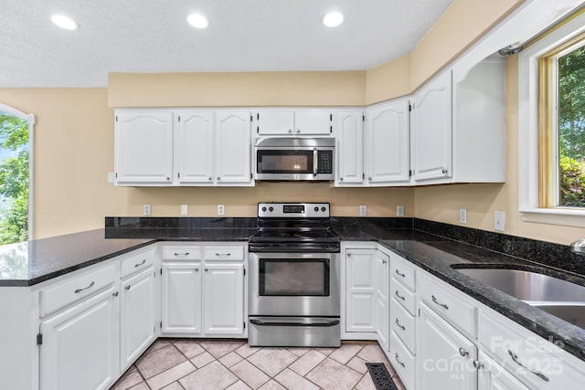 698 Normandy Rd, Mooresville, NC 28117 - kitchen with stainless steel appliances, white cabinets, recessed lighting, a peninsula, and dark stone countertops