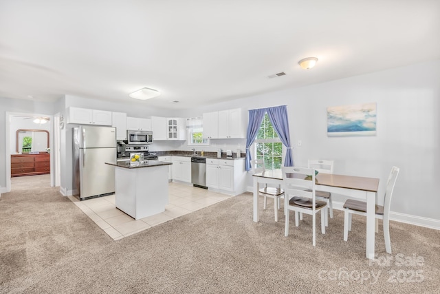 698 Normandy Rd, Mooresville, NC 28117 - kitchen with light carpet, appliances with stainless steel finishes, dark countertops, white cabinets, and glass insert cabinets