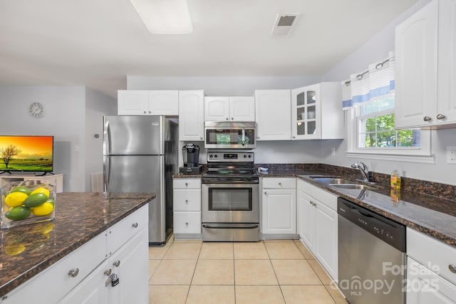 698 Normandy Rd, Mooresville, NC 28117 - kitchen featuring appliances with stainless steel finishes, white cabinetry, light tile patterned floors, and dark stone counters