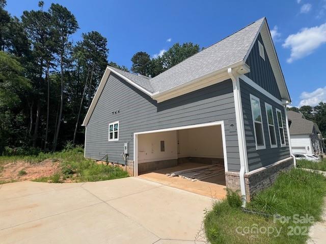 3218 Player Ct, Salisbury, NC 28144 - view of property exterior featuring board and batten siding, driveway, and a garage