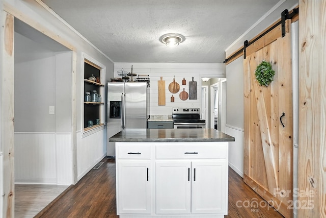 602 Unity St, Fort Mill, SC 29715 - kitchen with stainless steel appliances, a barn door, dark wood finished floors, a textured ceiling, and white cabinets