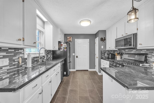5476 Twelve Oak Ln, Conover, NC 28613 - kitchen featuring stainless steel appliances, white cabinetry, tasteful backsplash, decorative light fixtures, and dark stone countertops