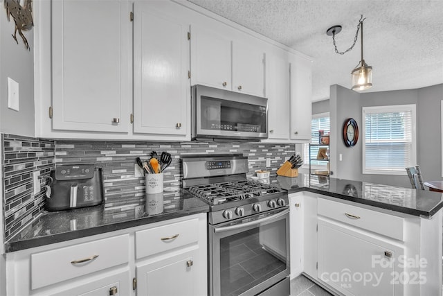 5476 Twelve Oak Ln, Conover, NC 28613 - kitchen featuring appliances with stainless steel finishes, a peninsula, a textured ceiling, white cabinets, and tasteful backsplash