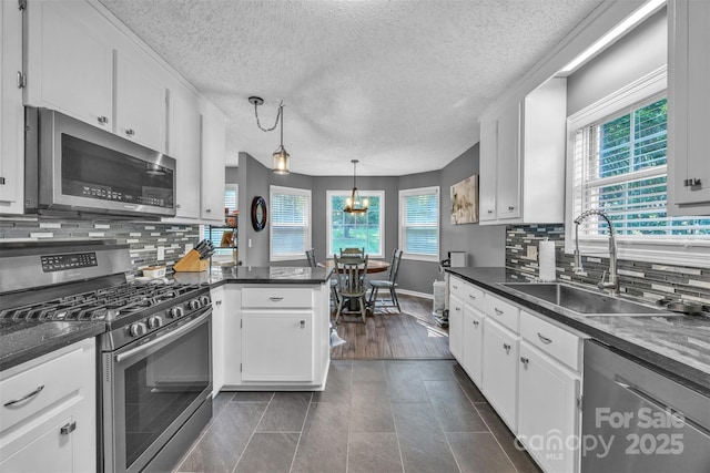 5476 Twelve Oak Ln, Conover, NC 28613 - kitchen featuring stainless steel appliances, dark countertops, white cabinetry, and a textured ceiling
