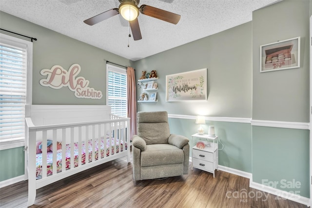 5476 Twelve Oak Ln, Conover, NC 28613 - bedroom with a crib, wood finished floors, a textured ceiling, and ceiling fan