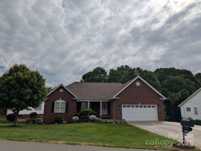 1764 Pipers Ridge Cir NW, Conover, NC 28613 - ranch-style house featuring brick siding, driveway, an attached garage, and a front lawn