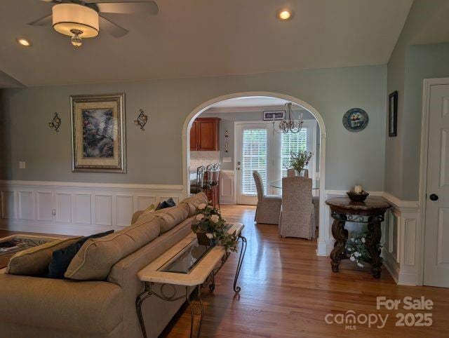 1764 Pipers Ridge Cir NW, Conover, NC 28613 - living area with arched walkways, a chandelier, light wood-style flooring, a wainscoted wall, and recessed lighting