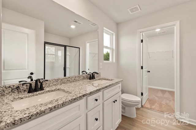 1041 Russell Dr, Winston Salem, NC 27127 - full bathroom with a spacious closet, a stall shower, double vanity, and wood finished floors