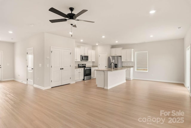 1048 Russell Dr, Winston Salem, NC 27127 - kitchen with appliances with stainless steel finishes, open floor plan, a center island with sink, recessed lighting, and light wood finished floors