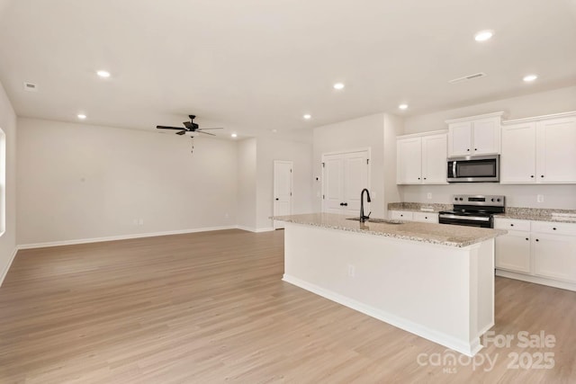 1048 Russell Dr, Winston Salem, NC 27127 - kitchen featuring stainless steel appliances, light wood-style flooring, ceiling fan, recessed lighting, and white cabinets