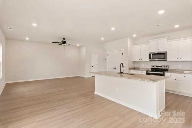 1048 Russell Dr, Winston Salem, NC 27127 - kitchen featuring stainless steel appliances, light wood-type flooring, a ceiling fan, recessed lighting, and white cabinetry