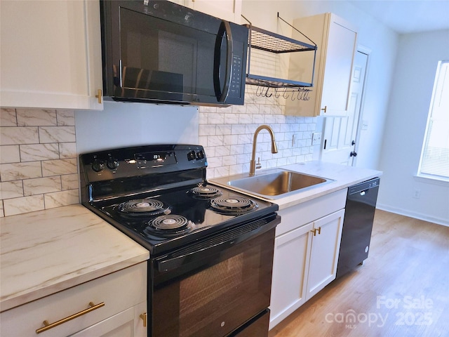 3106 Faircroft Way, Monroe, NC 28110 - kitchen with black appliances, backsplash, white cabinetry, light wood-style flooring, and light stone counters