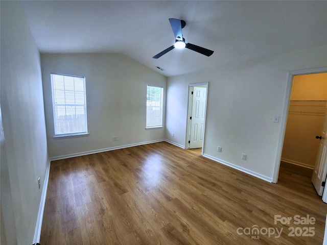 3106 Faircroft Way, Monroe, NC 28110 - unfurnished bedroom featuring wood finished floors, lofted ceiling, a walk in closet, and a ceiling fan