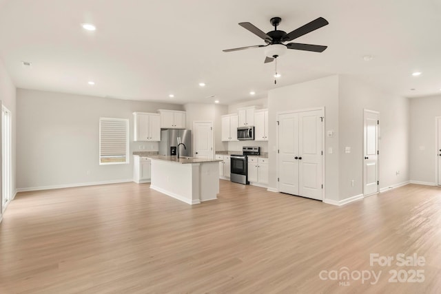 1072 Russell Dr, Winston Salem, NC 27127 - kitchen with appliances with stainless steel finishes, open floor plan, a kitchen island with sink, white cabinetry, and recessed lighting