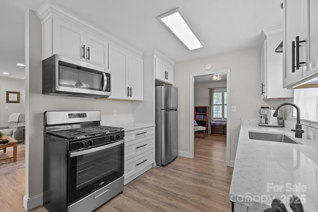 115 Fox Run Dr, Fort Mill, SC 29715 - kitchen with appliances with stainless steel finishes, light wood-type flooring, white cabinets, light stone counters, and recessed lighting