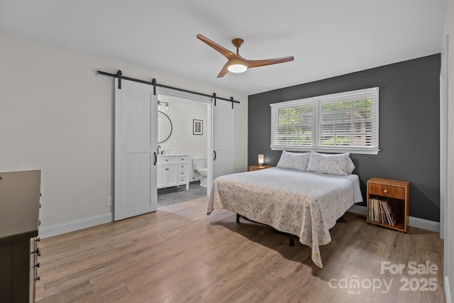 115 Fox Run Dr, Fort Mill, SC 29715 - bedroom featuring a barn door, wood finished floors, a ceiling fan, and connected bathroom
