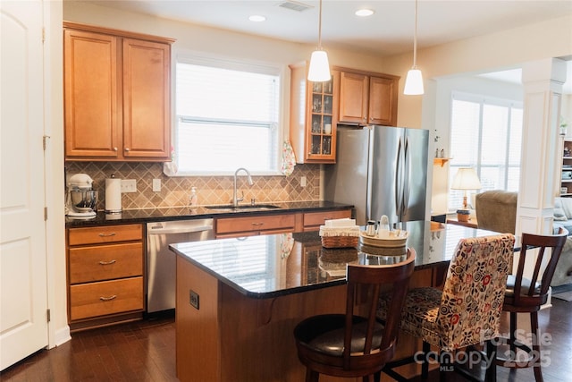 1156 Mckee Farm Ln, Belmont, NC 28012 - kitchen featuring stainless steel appliances, dark wood-style flooring, a kitchen bar, backsplash, and brown cabinetry
