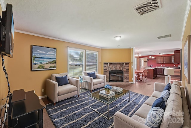1069 Heather Glen Dr, Catawba, NC 28609 - living room featuring wood finished floors, a brick fireplace, crown molding, and a textured ceiling