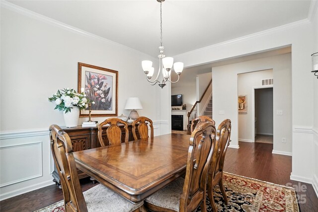 10120 Berkeley Castle Dr, Charlotte, NC 28273 - dining space featuring a chandelier, dark wood finished floors, crown molding, and stairs