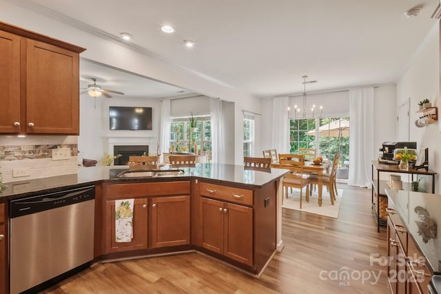 137 Branchview Dr, Mooresville, NC 28115 - kitchen featuring dishwasher, brown cabinetry, a peninsula, a fireplace, and light wood-type flooring