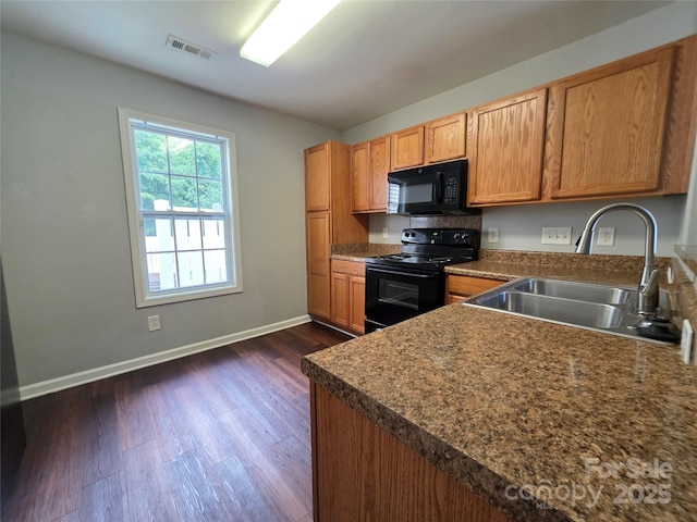 7315 Fig Ln, Charlotte, NC 28215 - kitchen featuring black appliances, dark wood-style floors, dark countertops, and brown cabinetry